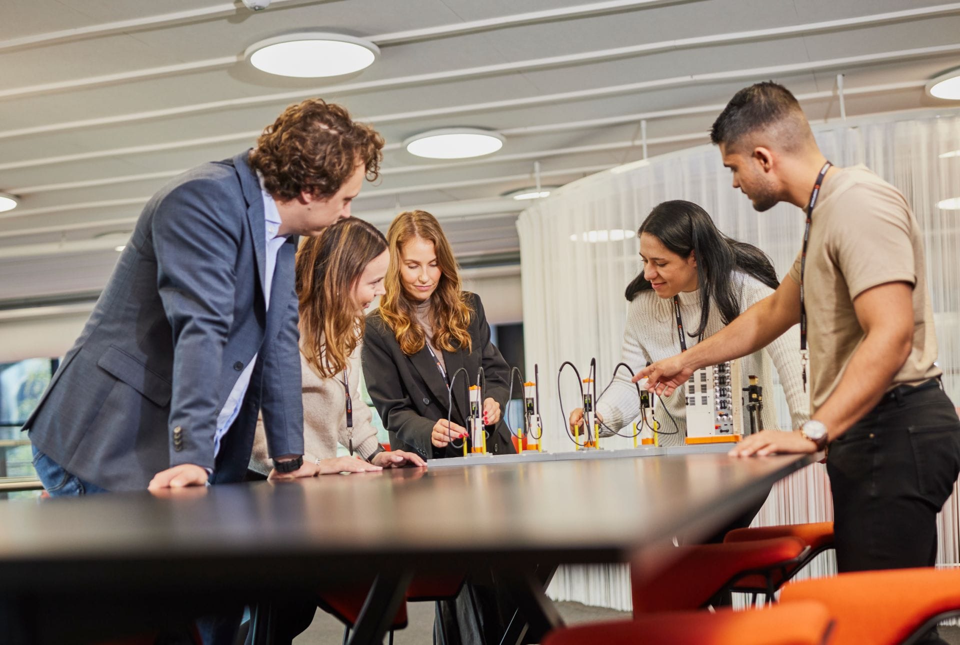 A team of designers and engineers gathered around a design model of an EV charging station.